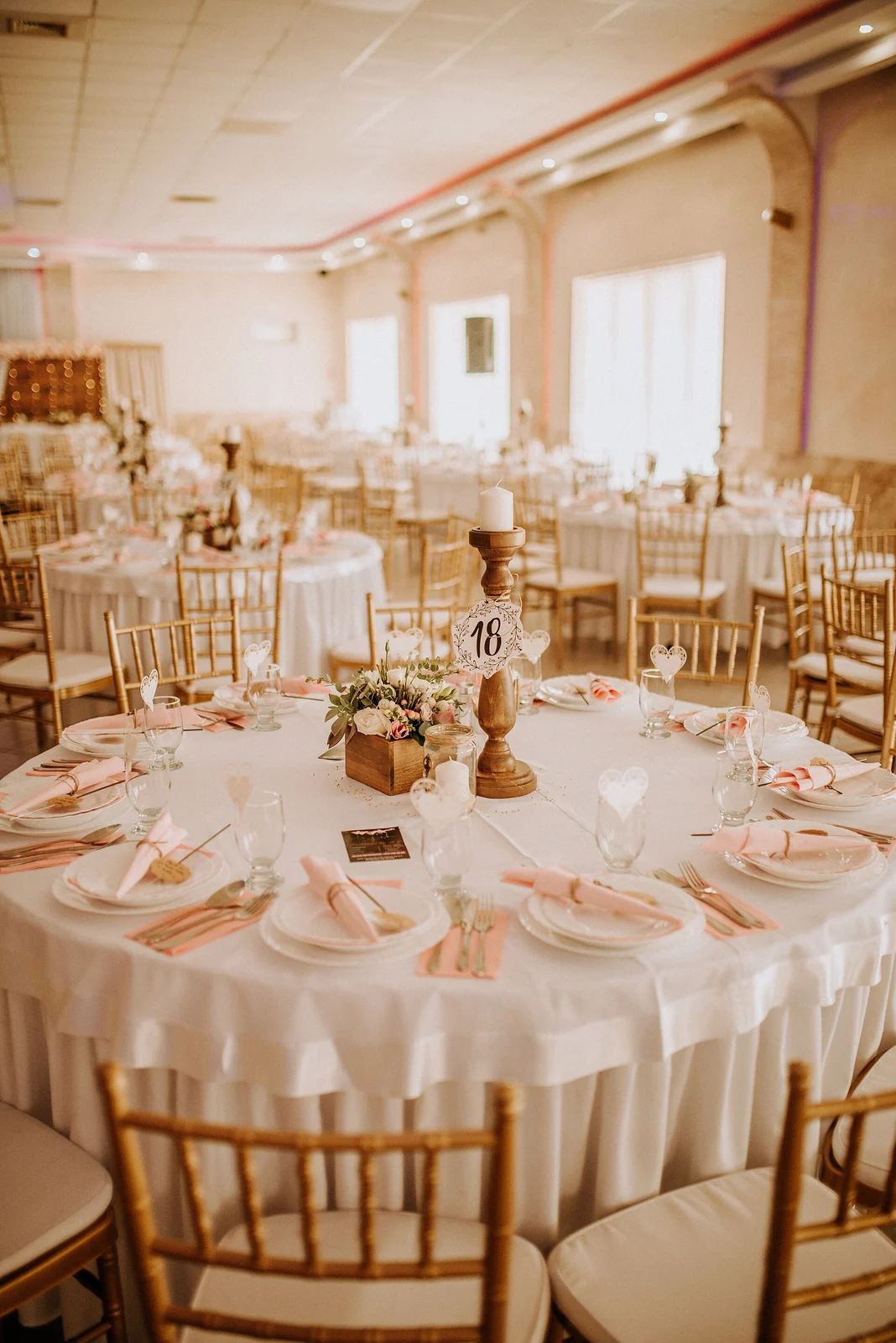 Salle préparée pour une réception avec tables dressées.